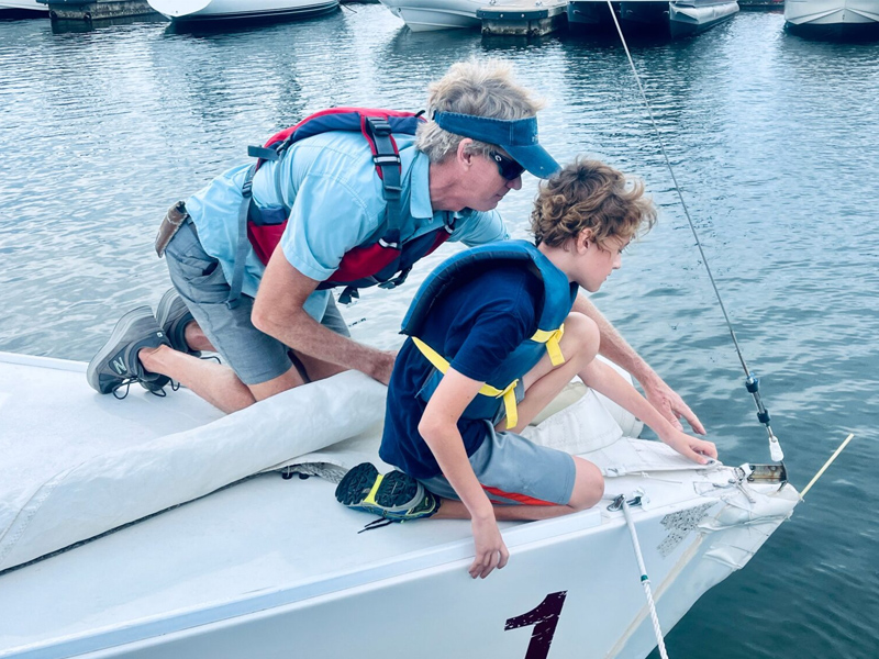 Child and adult at front of sailboat